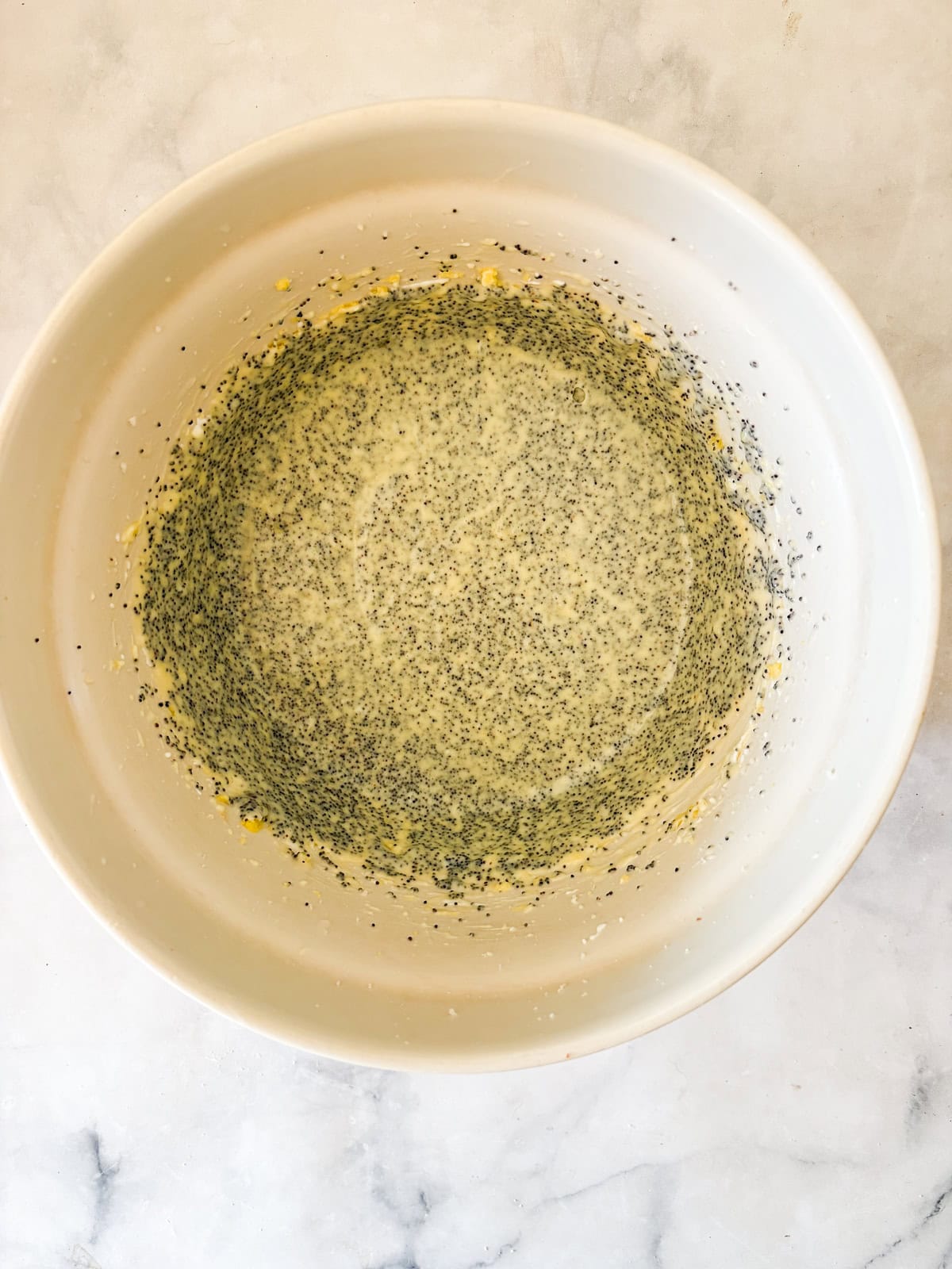 his gluten-free poppyseed cake is tender-crumbed, generously speckled with poppyseeds, and made with two simple flours. Gluten free poppyseed cake batter in a bowl.