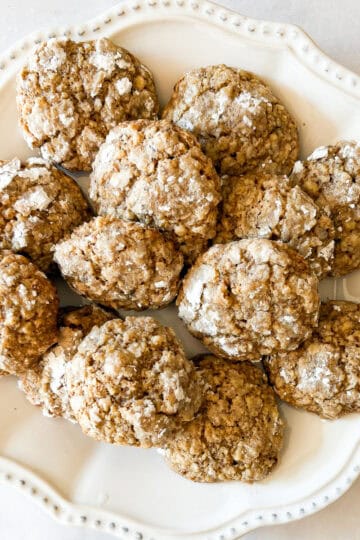 A plate of gluten free walnut cookies dusted with powdered sugar.
