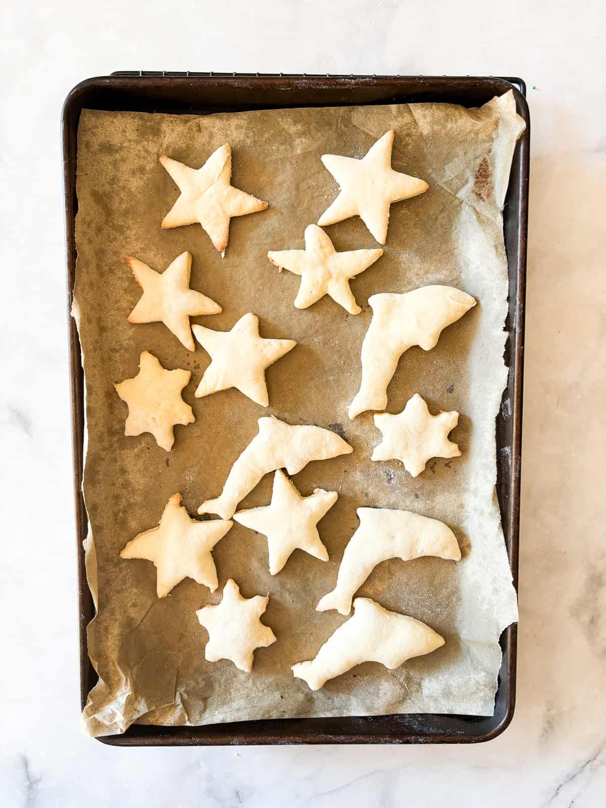 These kid-friendly, lower sugar sugar cookies feature all the buttery crispness of a classic sugar cookie, but with less sugar. GF option! Baked lower sugar sugar cookies cool on a baking sheet.