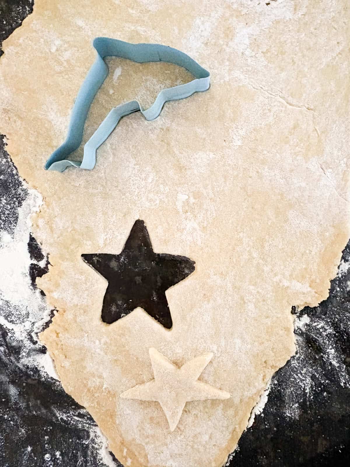 These kid-friendly, lower sugar sugar cookies feature all the buttery crispness of a classic sugar cookie, but with less sugar. GF option! Cutting out cookie dough for sugar cookies.