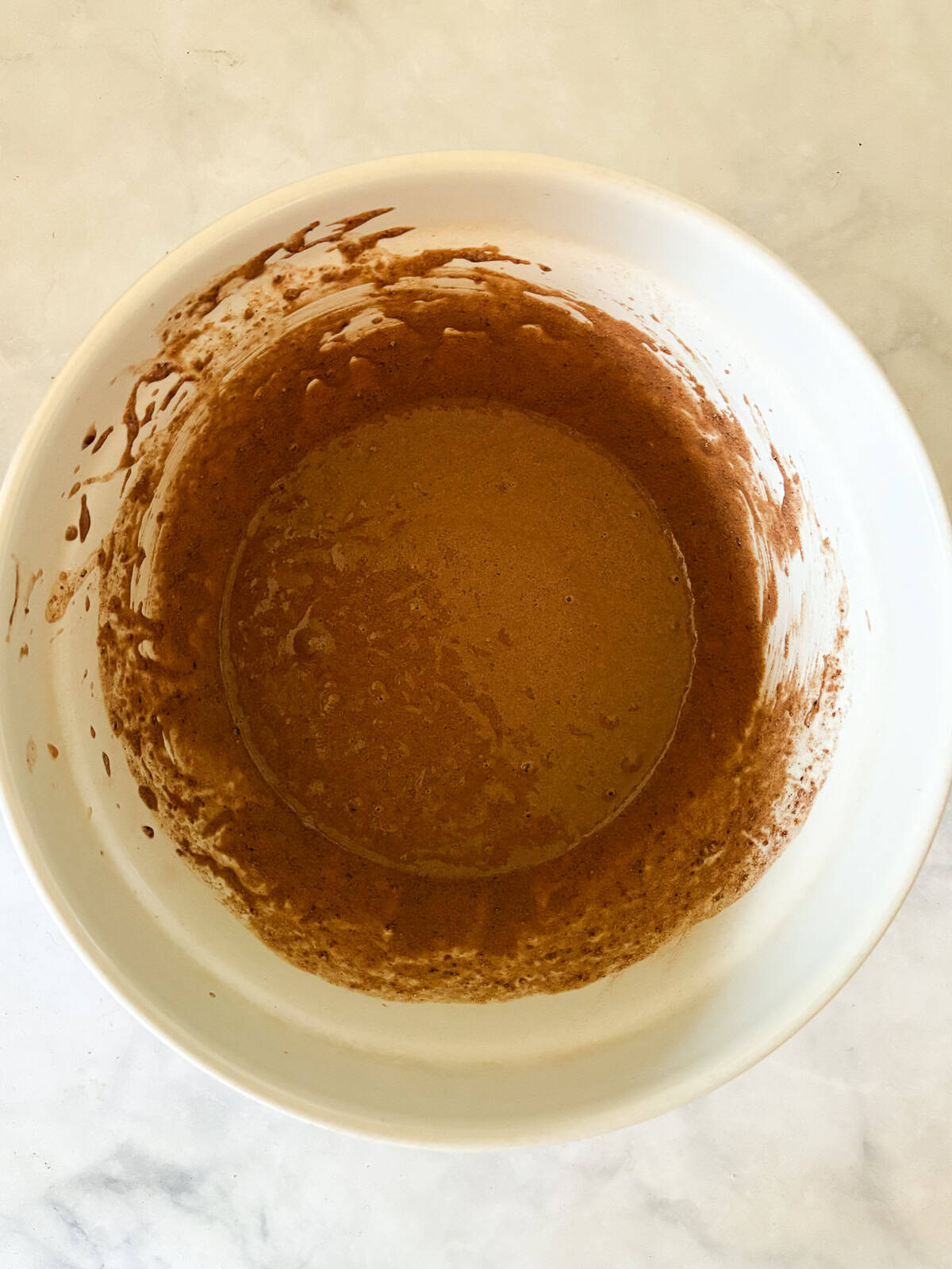 Delicious one-bowl vegan gluten-free chocolate cupcakes are made with oat flour and a handful of simple ingredients. So soft and fluffy! Wet ingredients are added to the bowl of cupcake batter.