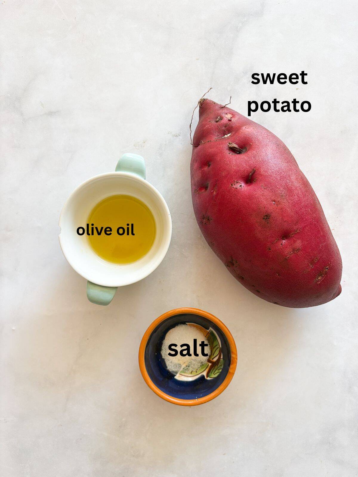 Cubed sweet potatoes are dressed in olive oil and salt and baked until sweet and soft. A great weeknight or holiday side dish. The ingredients for baked sweet potato cubes are text-labeled.