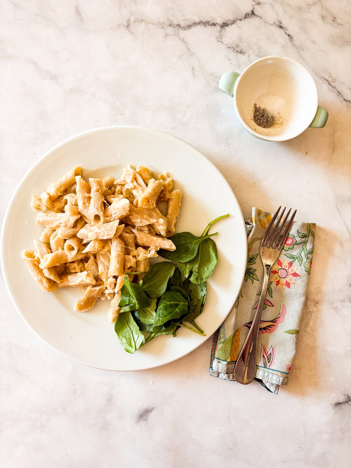 This creamy gluten free baked mac and cheese is just as good as the classic, and it's lightened up a bit but still feels indulgent. A plate of gluten free mac and cheese with salt and pepper next to it.