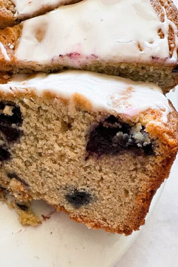 Slices of gluten free blueberry cake topped with lemon glaze.