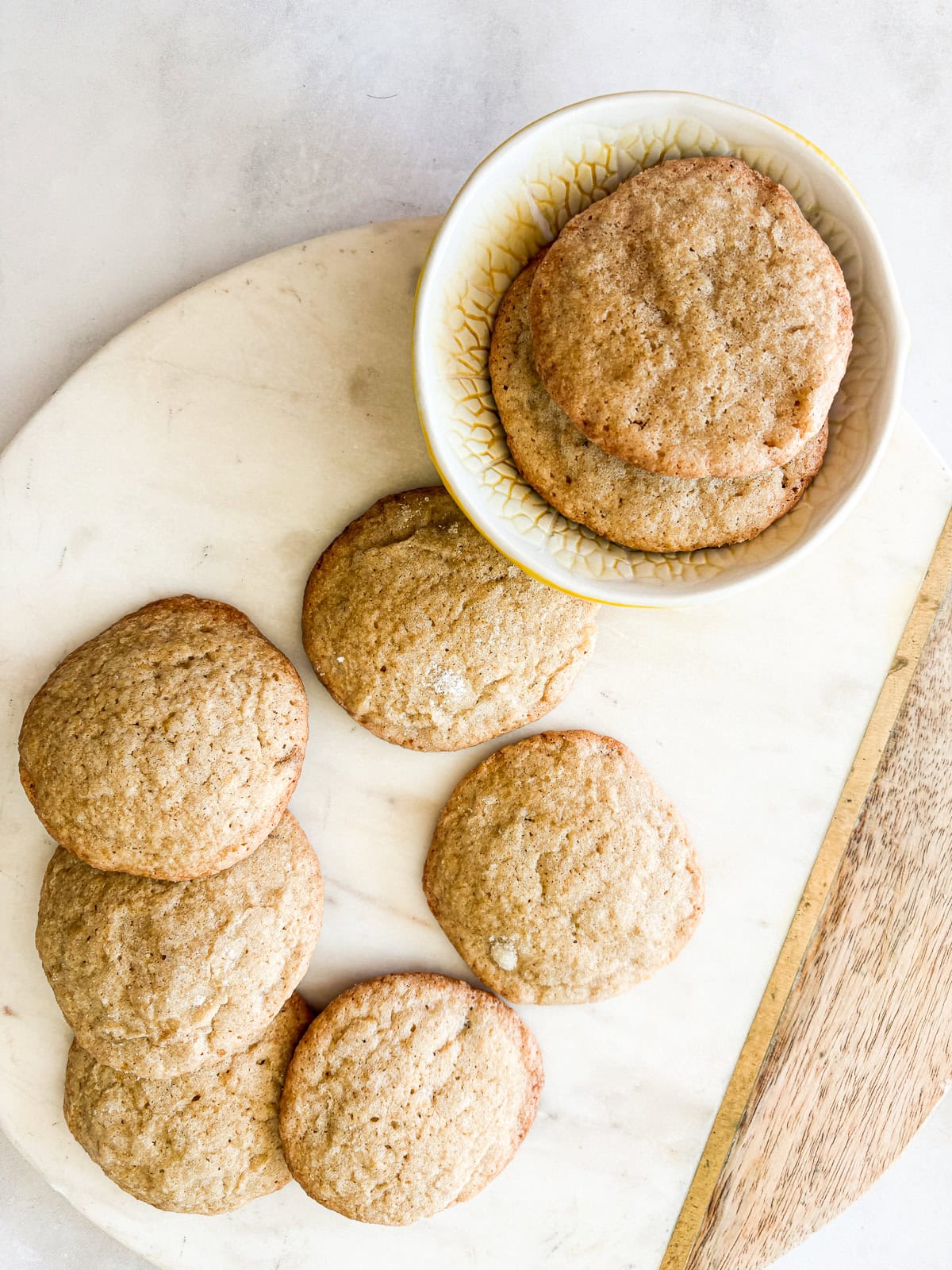 These soft and chewy gluten free lemon cookies are super flavorful thanks to bright lemon zest. Just one gluten-free flour is needed! Gluten free lemon cookies are scattered on a plate.
