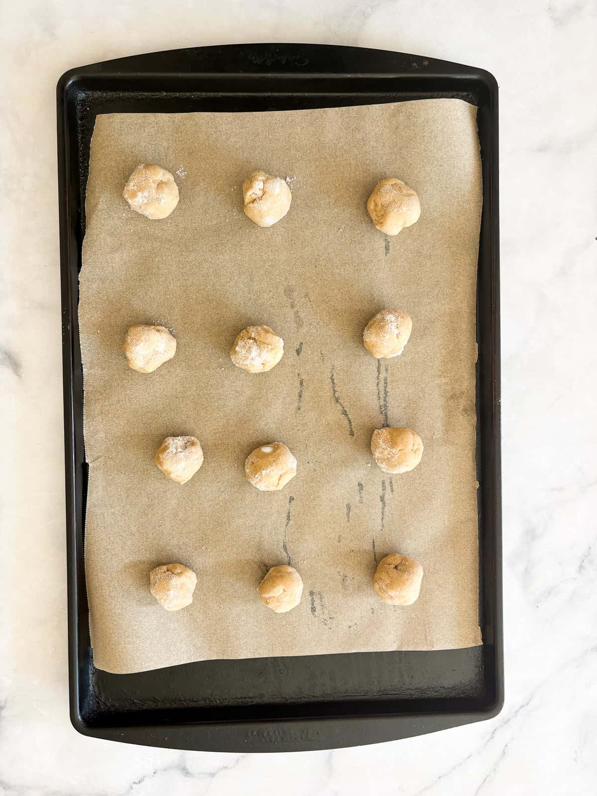 These soft and chewy gluten free lemon cookies are super flavorful thanks to bright lemon zest. Just one gluten-free flour is needed! Gluten free lemon cookie dough balls on a baking sheet.