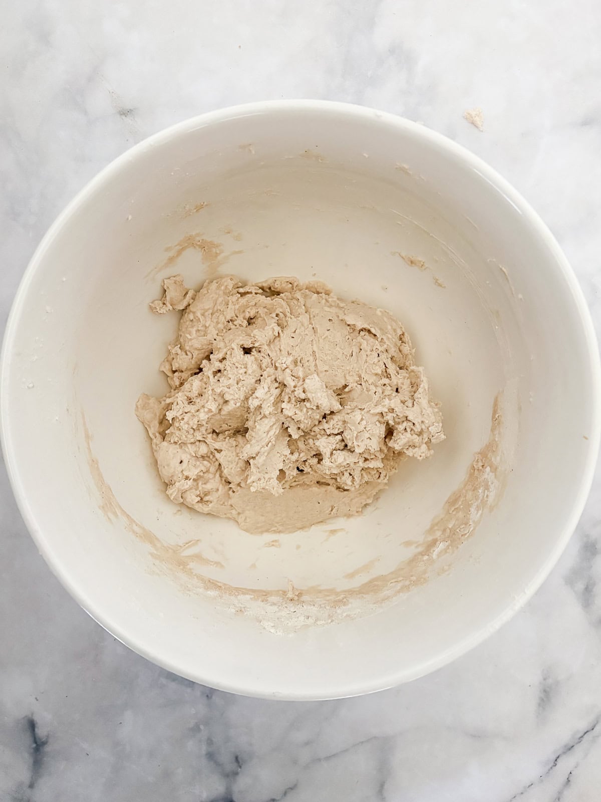 A crusty gluten-free no-knead bread recipe made with 4 simple ingredients. It bakes up perfectly every time and rivals any wheat-based bread! Ingredients for no knead gluten free bread are mixed in a bowl.
