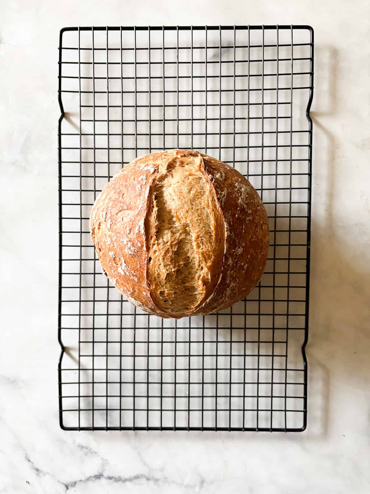 A crusty gluten-free no-knead bread recipe made with 4 simple ingredients. It bakes up perfectly every time and rivals any wheat-based bread! A loaf of gluten free no knead bread after baking fully.