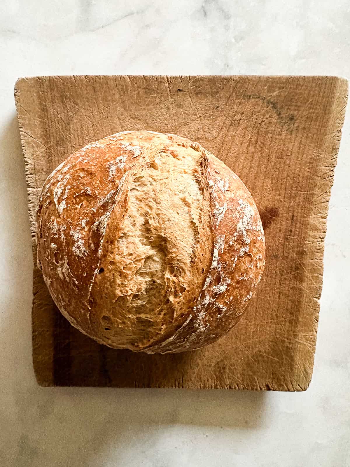 This gum-free, gluten free bread flour recipe is a go-to for breads and pastries of all kinds! Use it 1:1 in your favorite recipes. A loaf of gluten free no knead bread on a wooden cutting board.