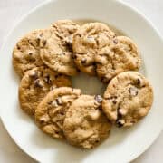 A white plate of gluten free peanut butter chocolate chip cookies.