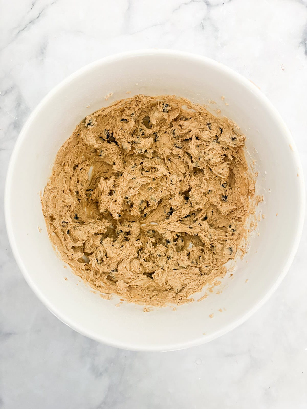 Chewy and irresistible, these gluten-free peanut butter chocolate chip cookies are made with plenty of creamy pb plus lots of chocolate! Dough for gluten free peanut butter chocolate chip cookies in a large bowl.
