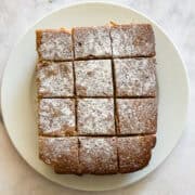 A gluten free snack cake on a plate, cut into pieces.