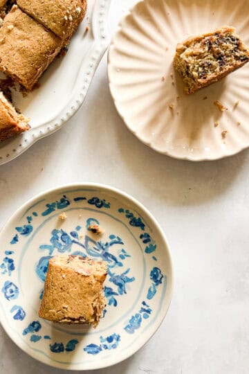 Two pieces of oat flour chocolate chip snack cake on plates next to the cake.