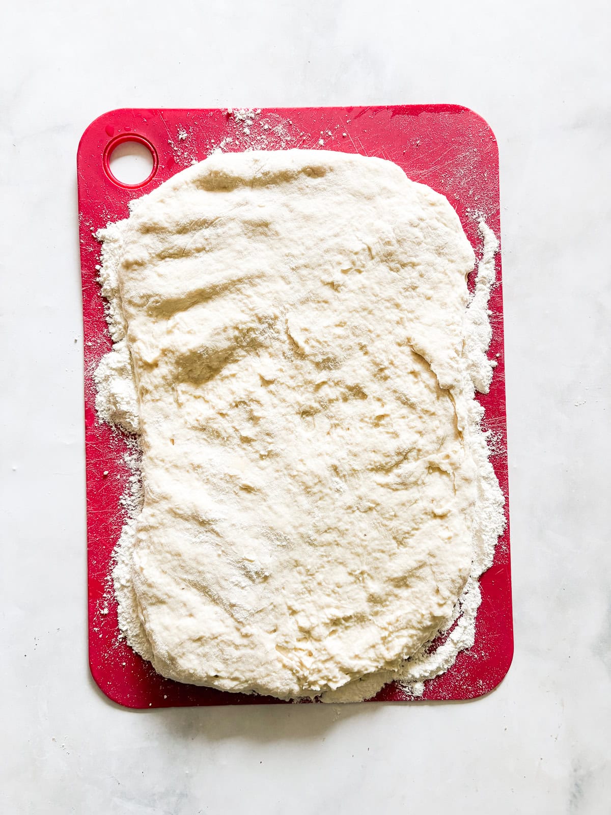 Tender and light soda biscuits need just five simple ingredients and an easy prep method - a keeper of a recipe! Dough for soda biscuits is patted out on a cutting board.