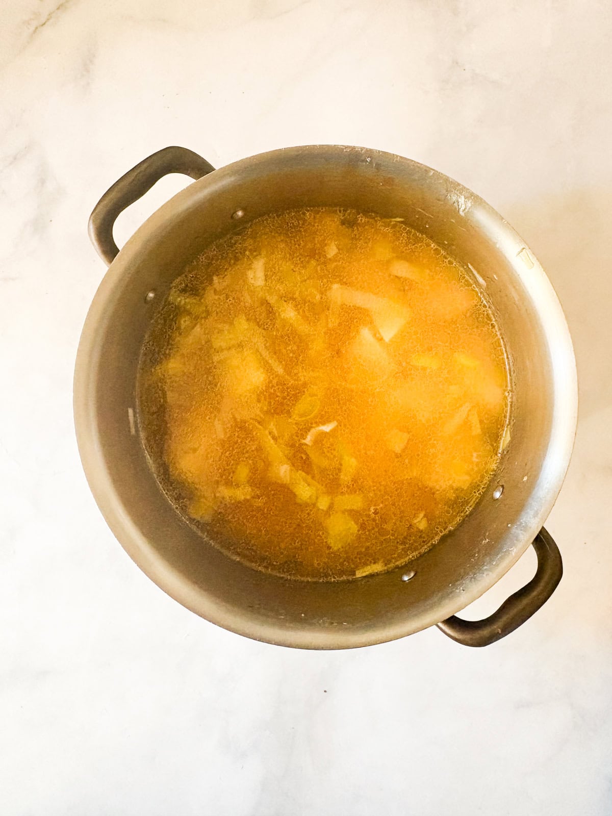 Rich and smooth vegetarian potato leek soup is made from simple ingredients that transform into something deliciously memorable. Broth is added to vegetarian potato lee soup.