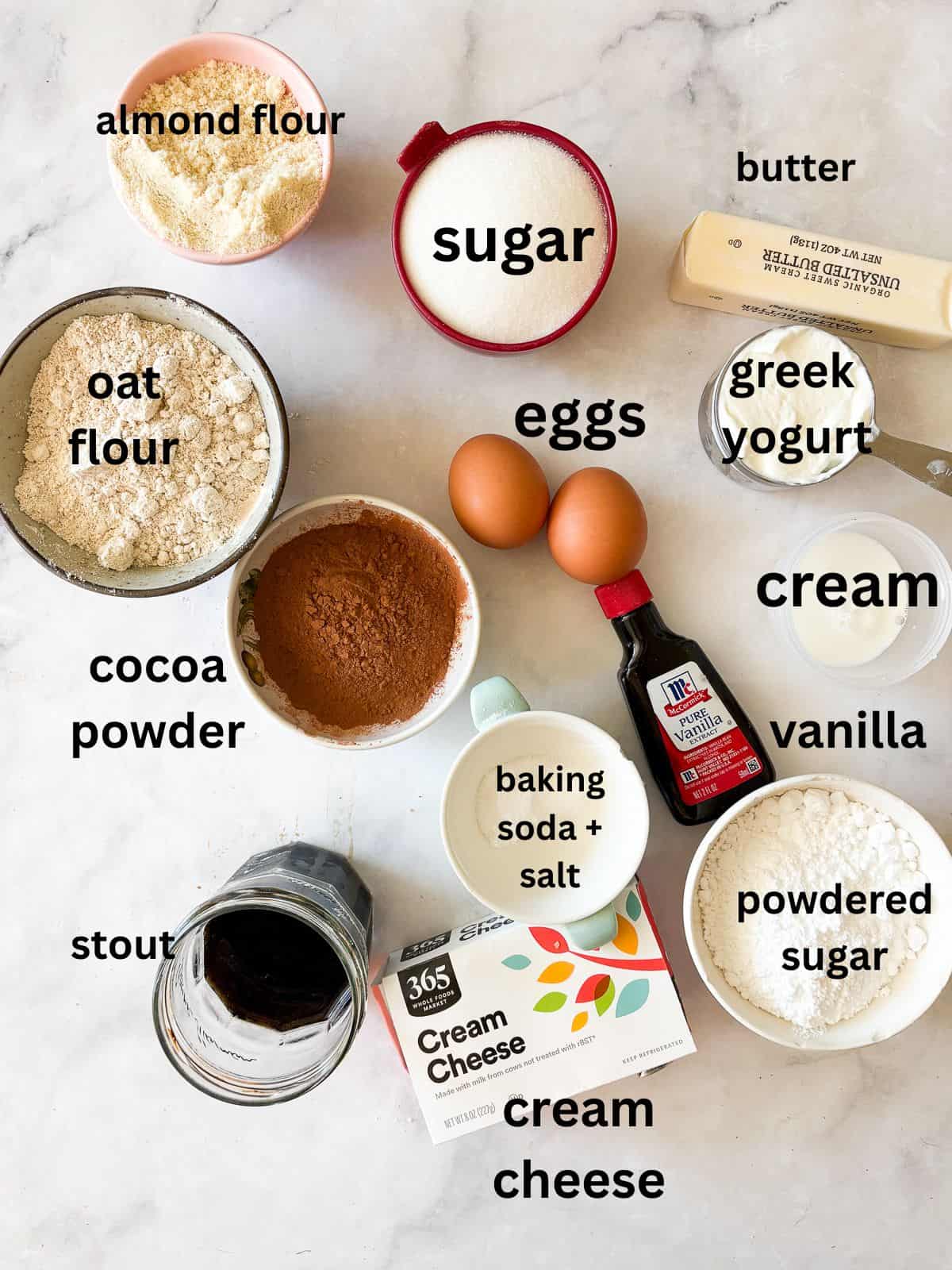 Gluten free Guinness chocolate cupcakes are dark, rich, and topped with a tangy-sweet cream cheese frosting. Ingredients for gluten free Guinness chocolate cupcakes are text-labeled.