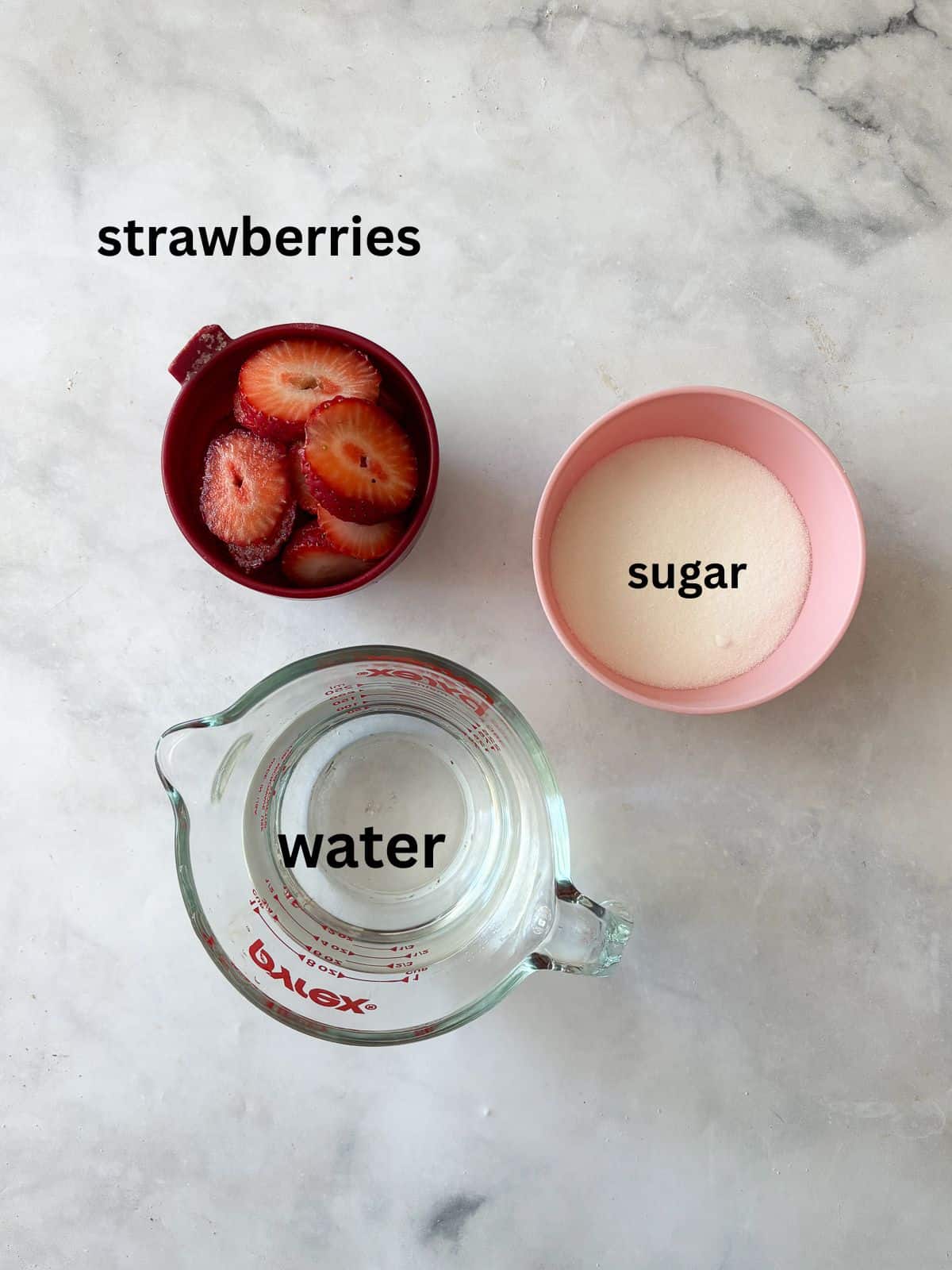 Three-ingredient strawberry simple syrup is so pretty when stirred into drinks or draped over cakes! A summer must-make. Ingredients for strawberry simple syrup are text-labeled.