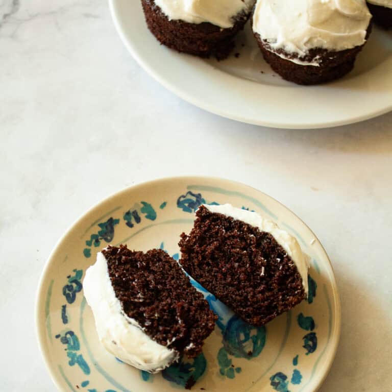 A Guinness chocolate cupcake cut in half on a plate.