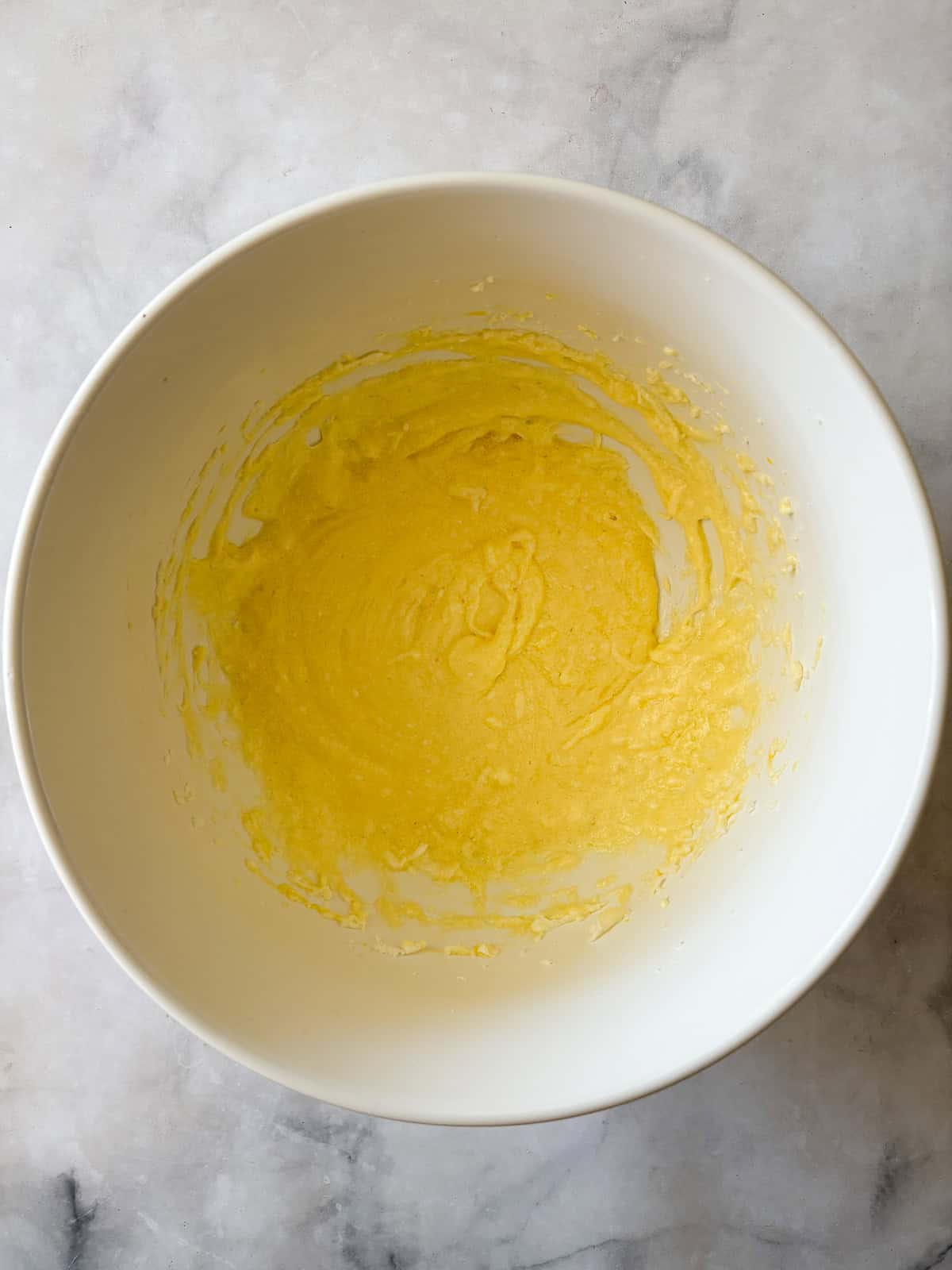 A soft and sweet gluten free Irish apple cake that's inspired by a traditional Irish recipe. Delicious plain, it can be served warm or cold. Butter, sugar, and eggs mixed in a bowl for gluten free Irish apple cake.