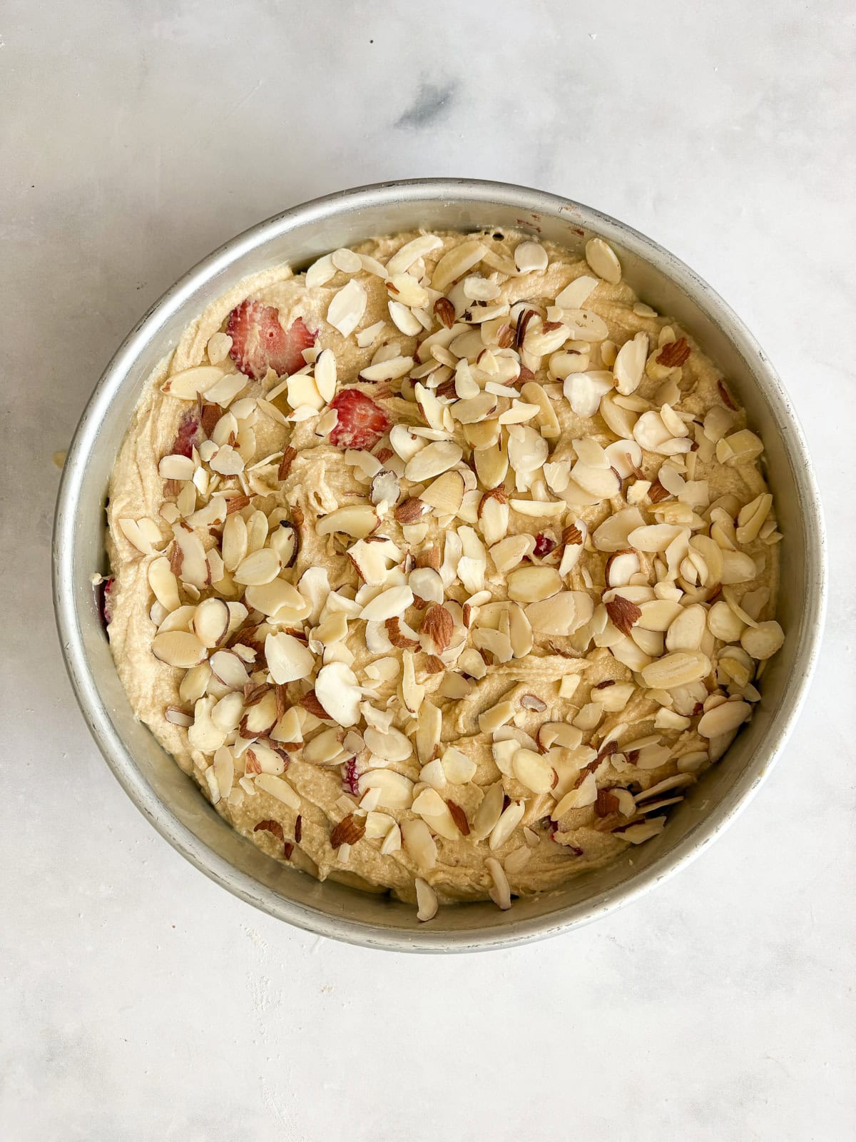 A gorgeous gluten free strawberry almond cake loaded with fresh fruit and topped with toasted almonds and a shower of powdered sugar. A strawberry almond cake topped with almonds.