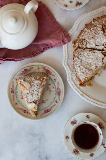 A pot of tea, a cup of tea, and a gluten free strawberry almond cake.