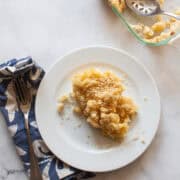 A serving of kids mac and cheese with a fork and napkin.