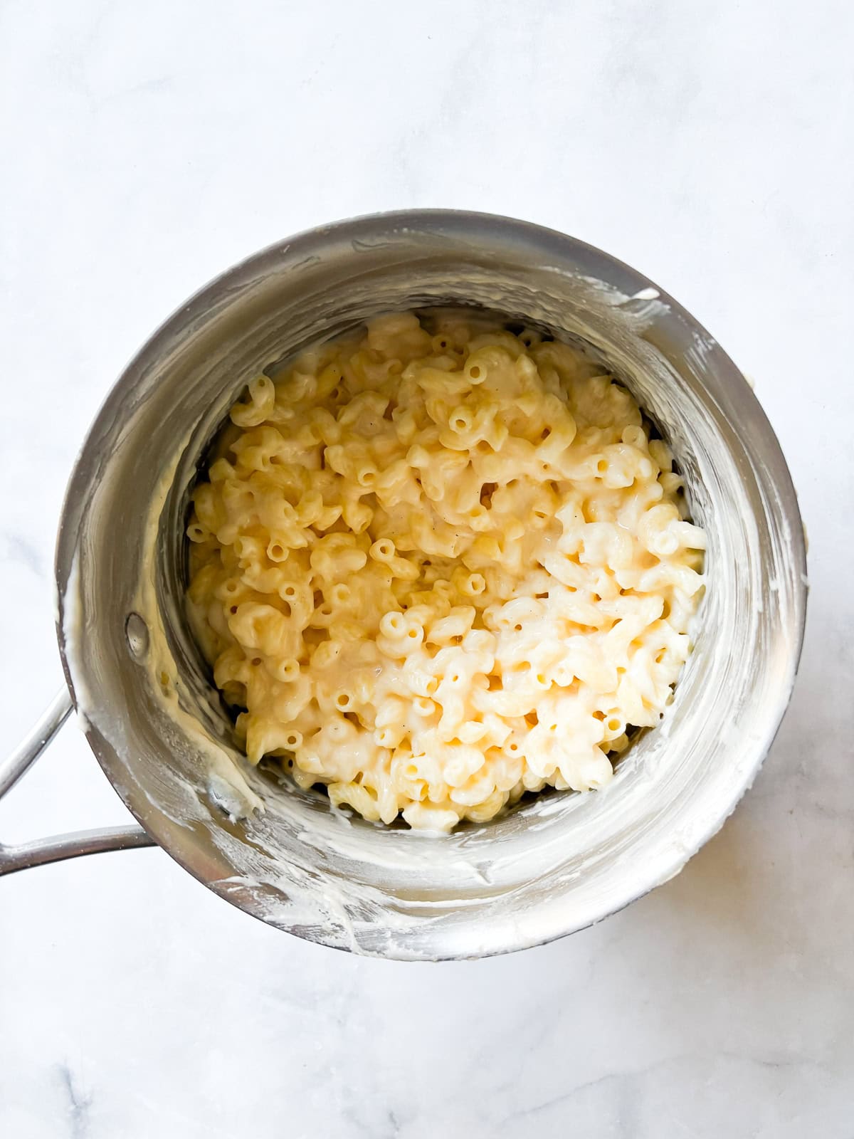 Every bite of this creamy, one pot gluten free mac and cheese delivers homemade comfort - so much better than store-bought! Fast and easy. Stirring pasta into the cheese sauce.