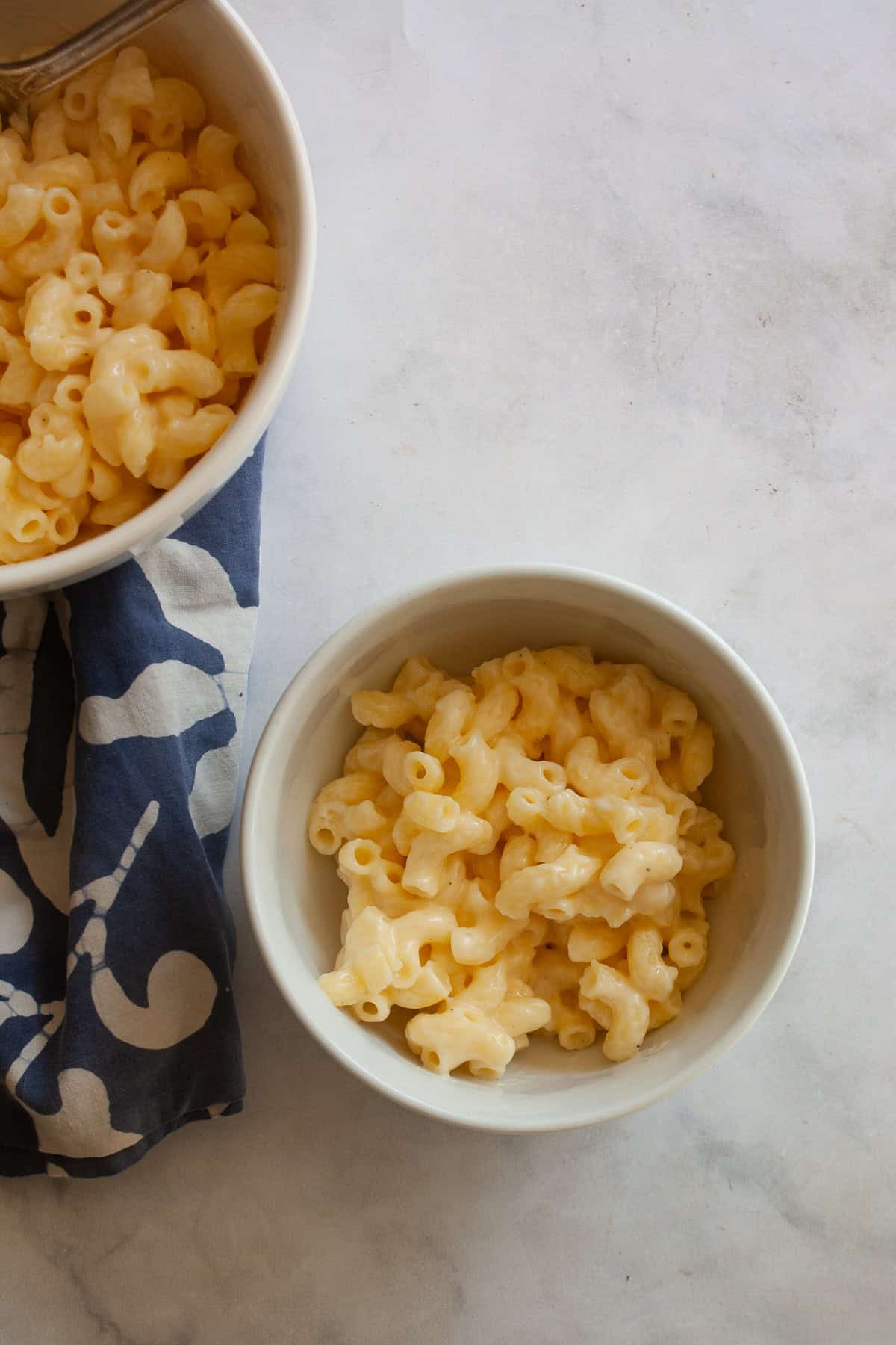 Every bite of this creamy, one pot gluten free mac and cheese delivers homemade comfort - so much better than store-bought! Fast and easy. Two bowls of one pot gluten free mac and cheese on a napkin.