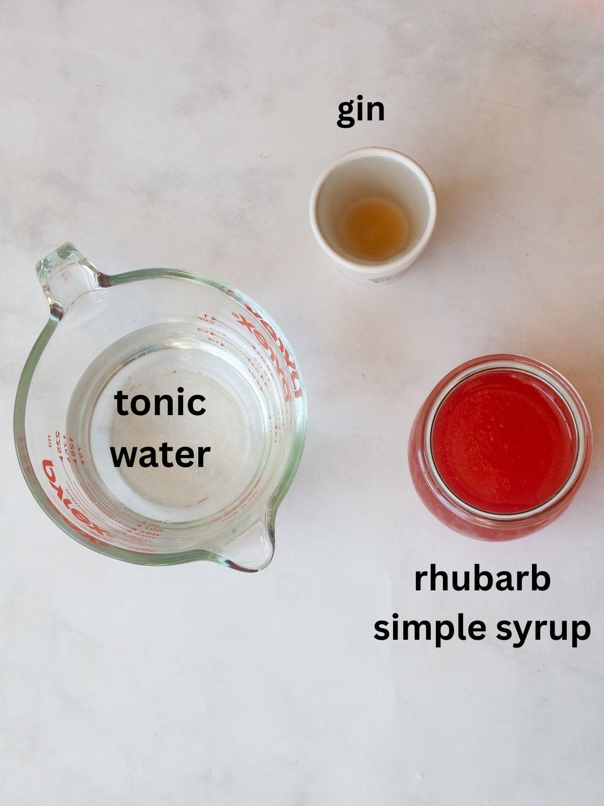 For a gorgeous twist on a classic, stir homemade rhubarb syrup into good gin and bubbly tonic water for a refreshing cocktail. Ingredients for a rhubarb gin and tonic are text-labeled.