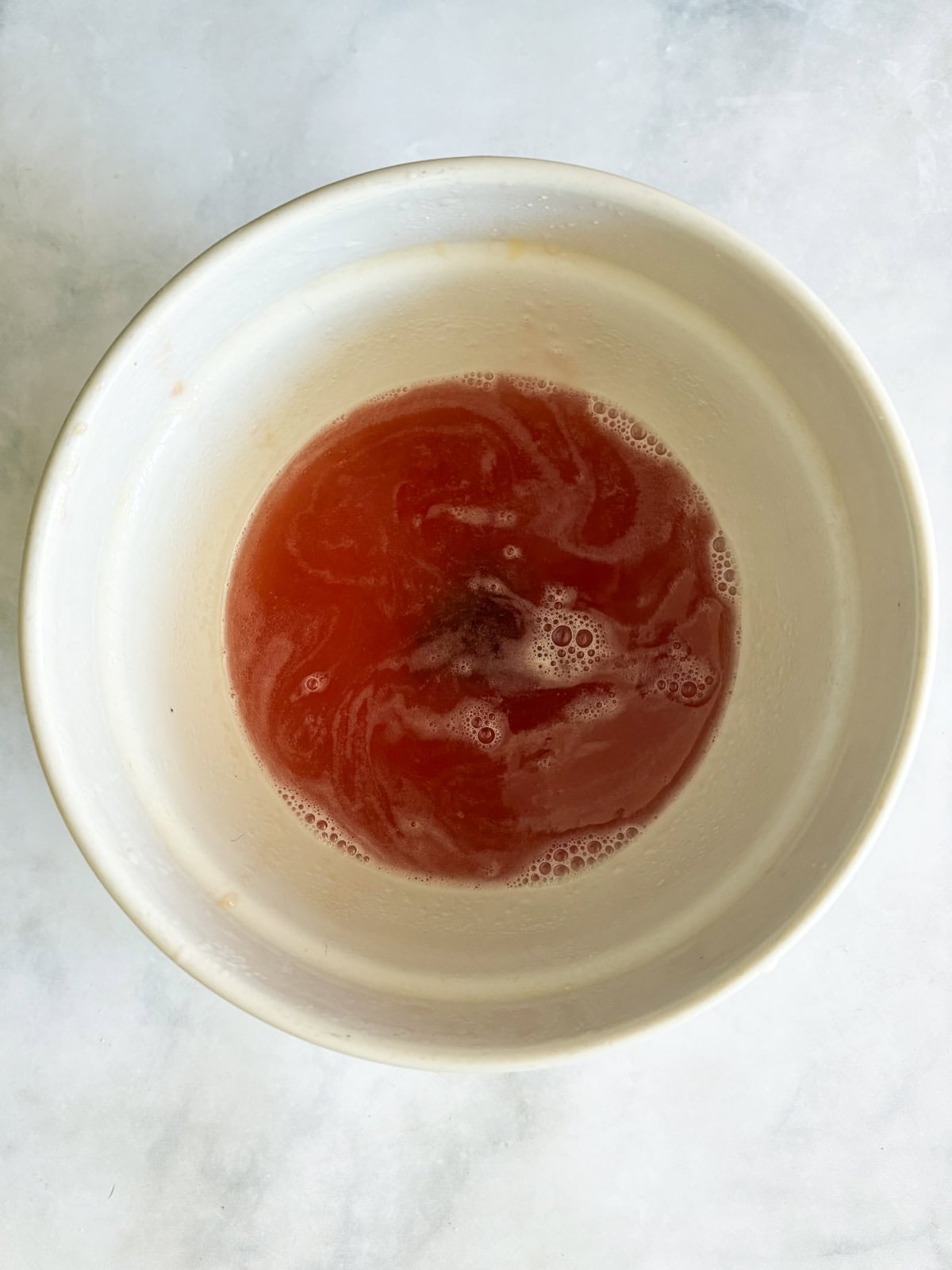 Gorgeously hued and perfectly sweet-tart, rhubarb simple syrup is a delightful addition to all sorts of drinks (and more). Rhubarb simple syrup in a bowl.