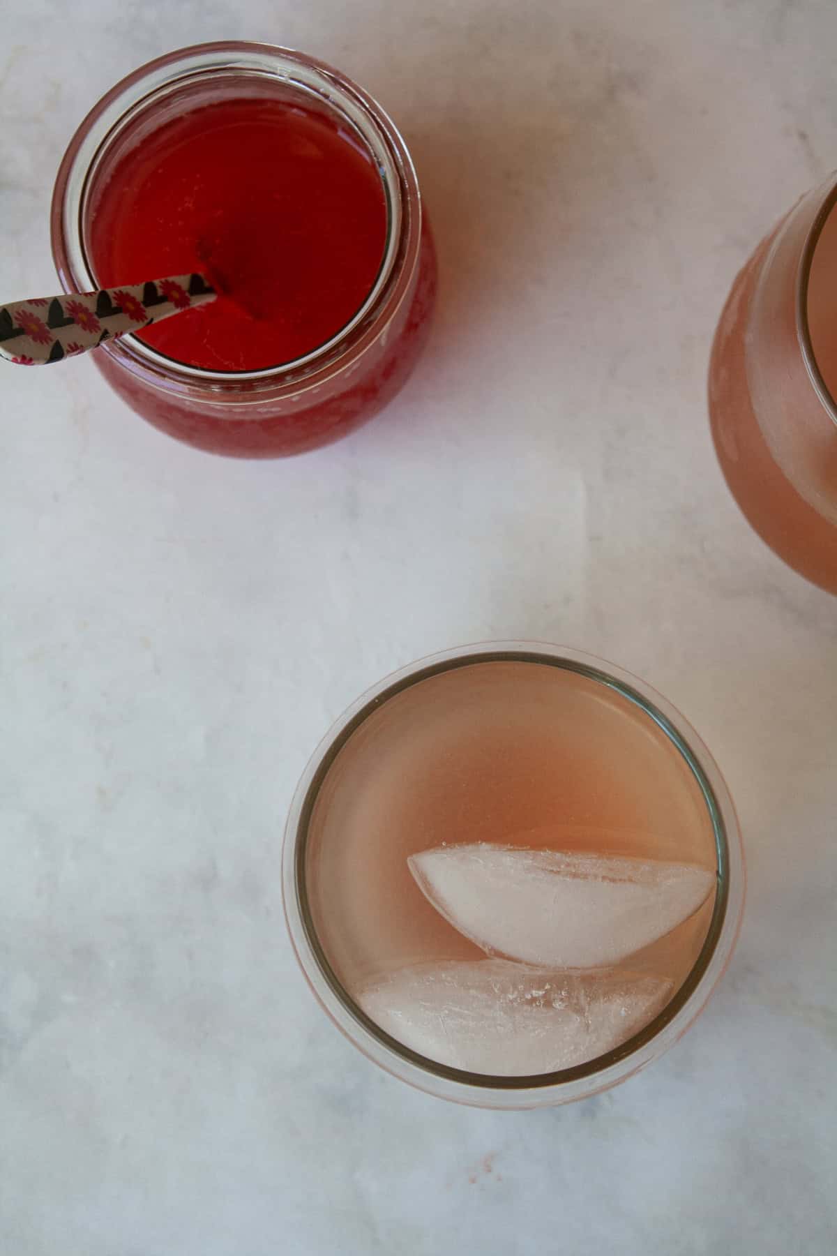Gorgeously hued and perfectly sweet-tart, rhubarb simple syrup is a delightful addition to all sorts of drinks (and more). A rhubarb gin and tonic and a jar of rhubarb simple syrup.