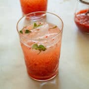 A glass of strawberry cocktail with mint.