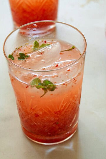A glass of strawberry cocktail with mint.