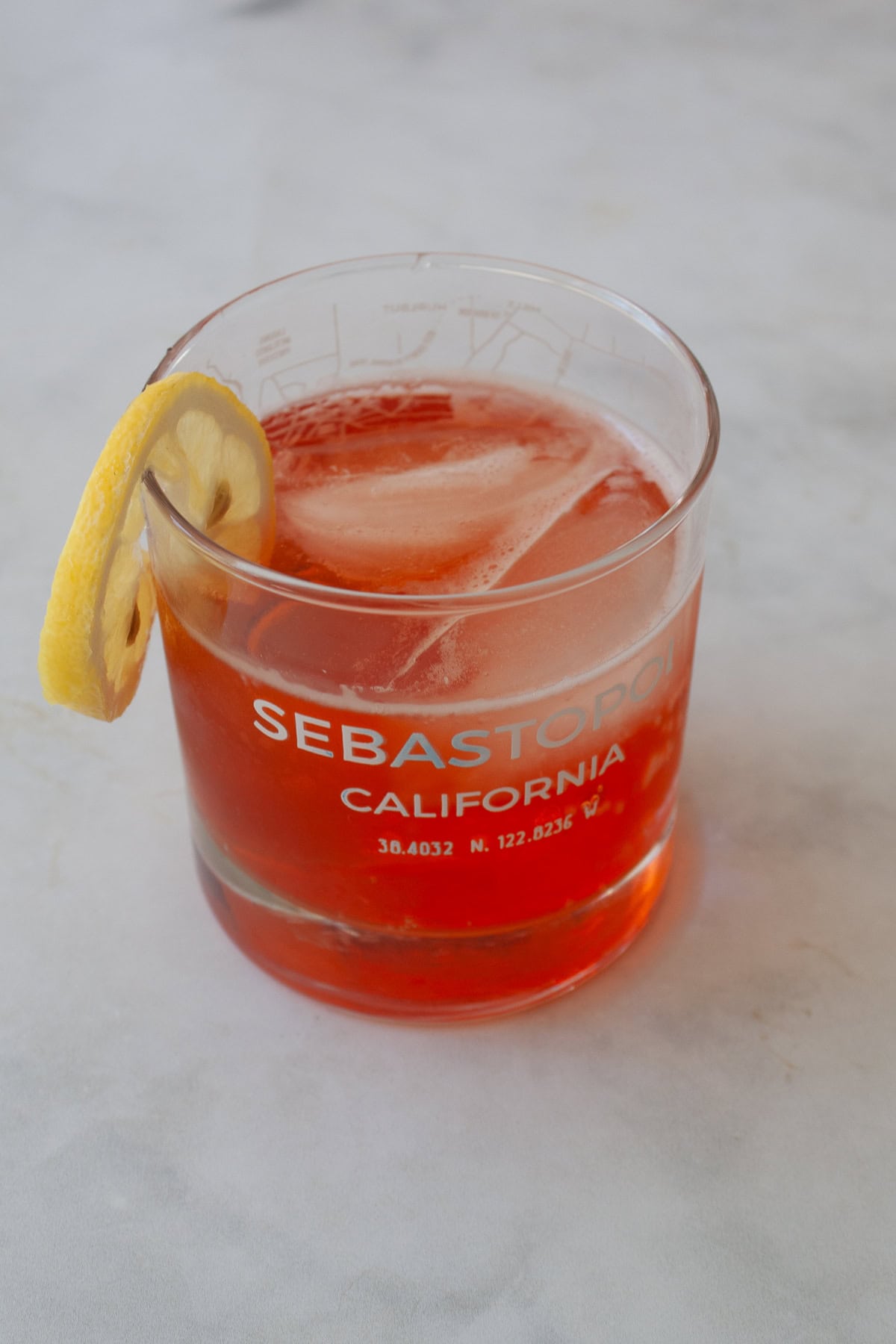Three-ingredient strawberry simple syrup is so pretty when stirred into drinks or draped over cakes! A summer must-make. A strawberry gin and tonic made with strawberry simple syrup.