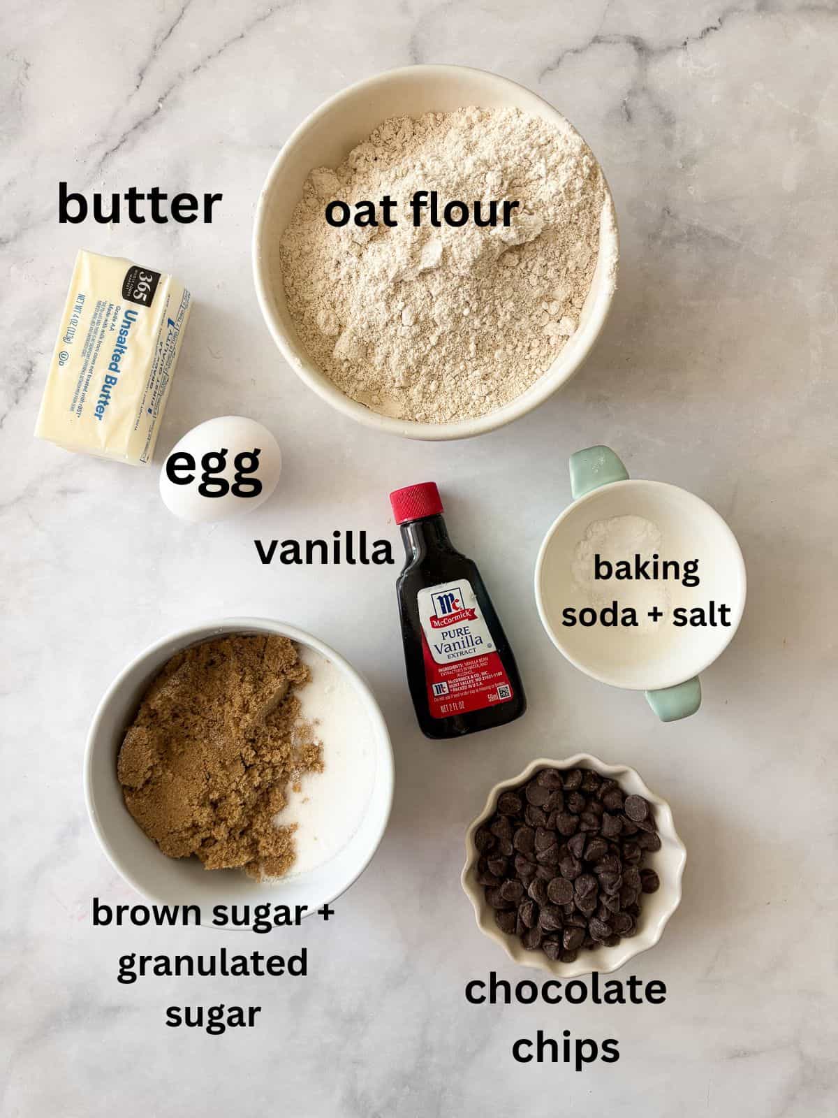 This sweet and chewy gluten free skillet cookie that's soooo good served warm and topped with ice cream. Made in one bowl! Ingredients for a gluten free skillet cookie are text-labeled.
