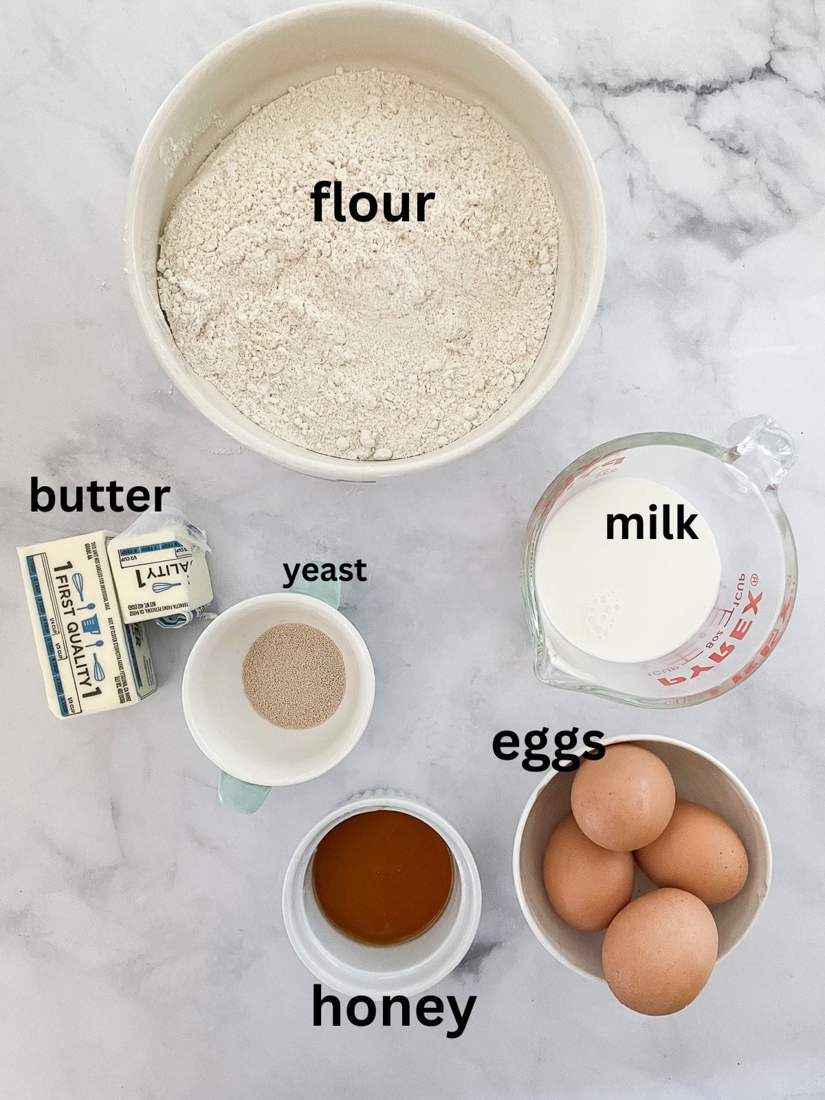 My homemade sticky buns recipe is make-ahead friendly and amazingly good! A thick maple syrup topping turns these into a bakery-worthy treat. Ingredients for sticky buns are text labeled.