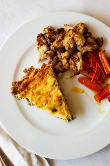 A plate of gluten free asparagus quiche and veggies.