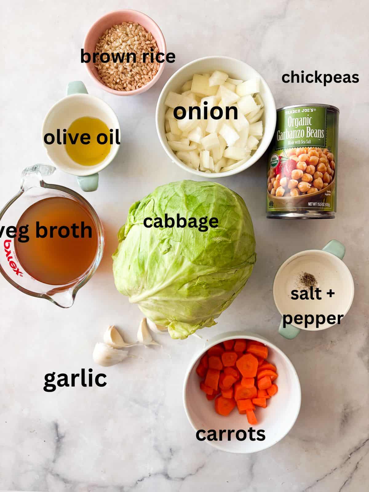 A brothy, satisfying vegetarian soup packed with tender cabbage, carrots, onions, garlic and plenty of chewy brown rice. Ingredients for vegetarian cabbage soup are text-labeled.