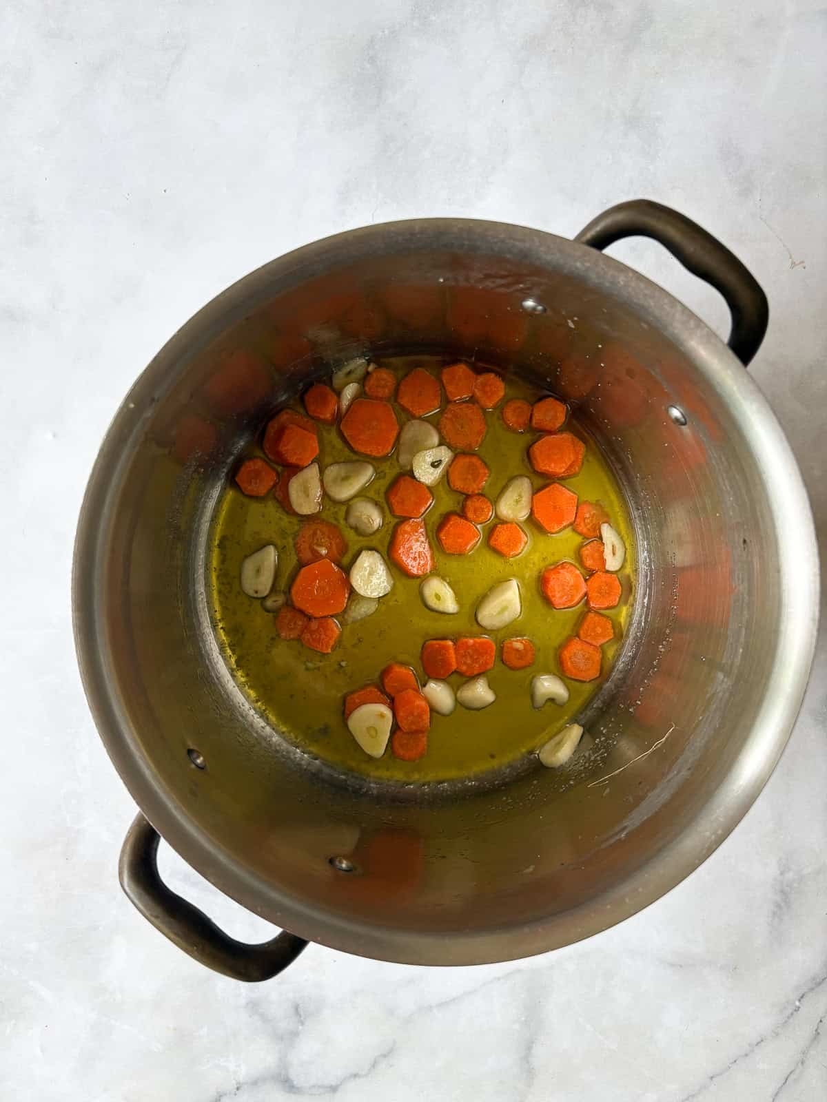 Creamy, vegan asparagus and spinach soup is made with minimal ingredients to create a velvety, nourishing soup that's always welcome. Garlic and carrots cook for asparagus and spinach soup.