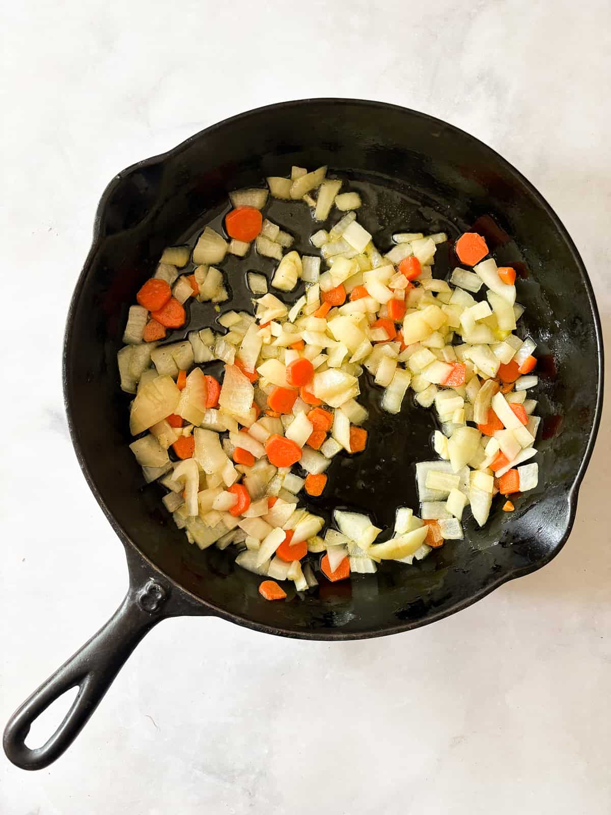 Quick, nourishing, and packed with savory veggies, tender cabbage, and hearty beans, this cabbage stir fry is super satisfying. Vegetarian! Onion, carrots, and garlic cook in olive oil.