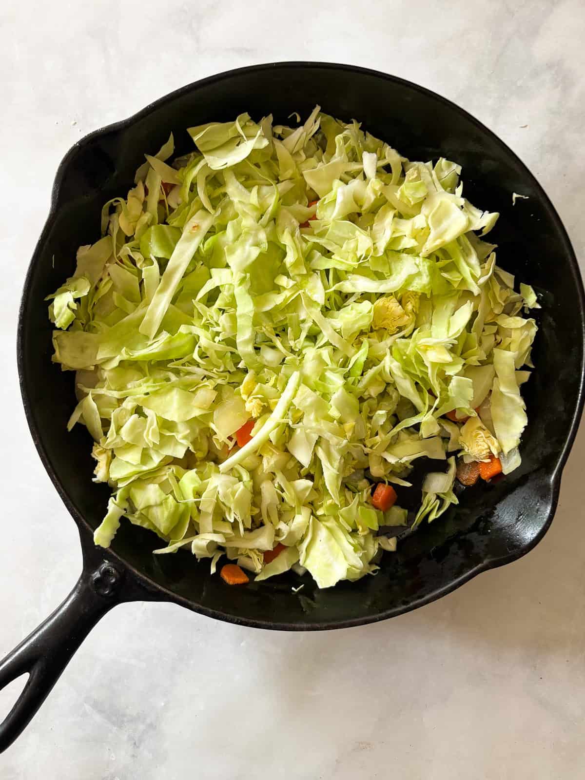 Quick, nourishing, and packed with savory veggies, tender cabbage, and hearty beans, this cabbage stir fry is super satisfying. Vegetarian! Chopped cabbage is added to the skillet of onion and carrots.