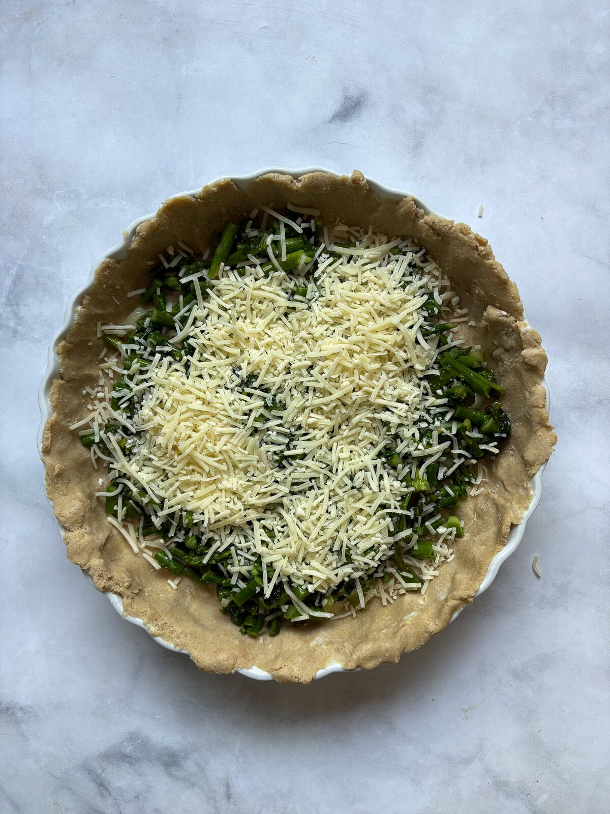 This gluten free asparagus quiche is packed with springy asparagus and salty parmesan cheese to make a wonderful brunch or dinner dish! Cheese tops asparagus in a pie crust for quiche.