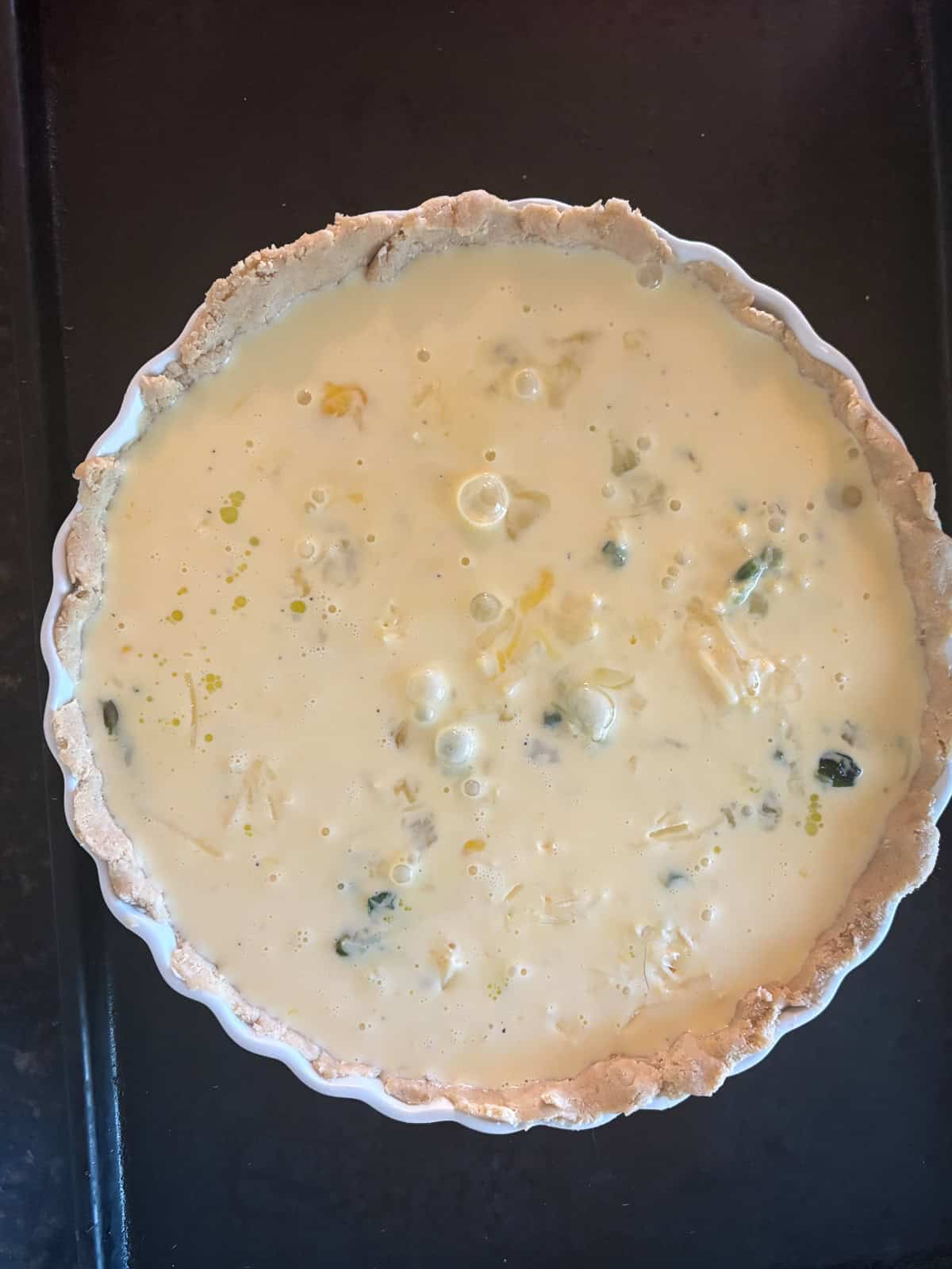 This gluten free asparagus quiche is packed with springy asparagus and salty parmesan cheese to make a wonderful brunch or dinner dish! Adding the milk egg mixture to the quiche.
