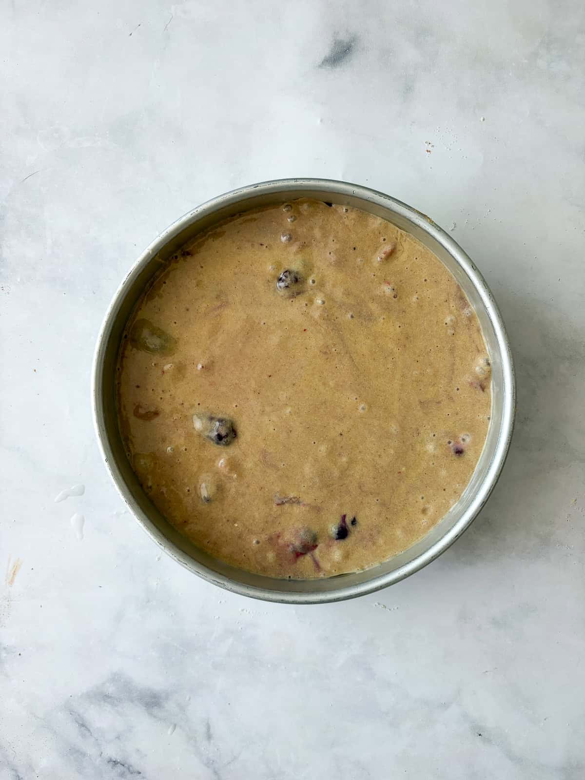 Batter for gluten free berry cake in a pan.