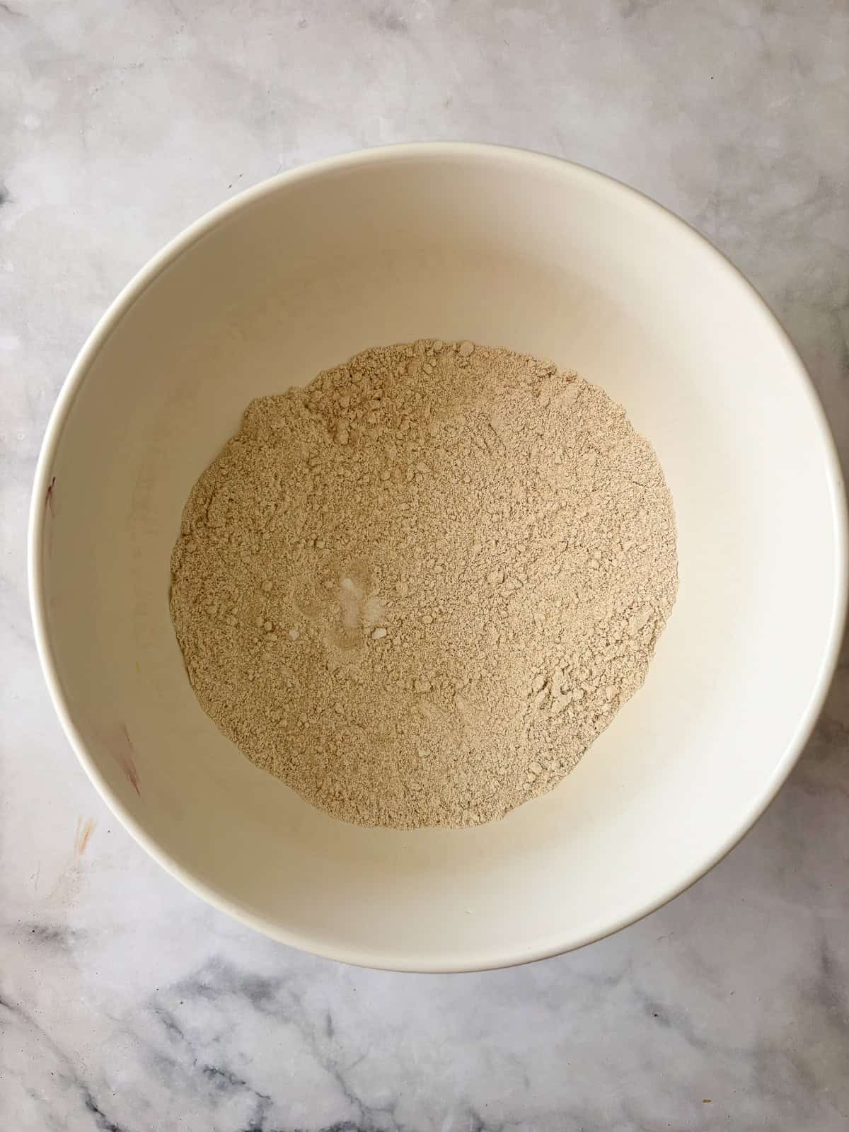 These one-bowl gluten-free berry muffins are made with your choice of whole grain flour and are sweetened just with maple syrup! Dry mix for gluten free berry muffins in a bowl.