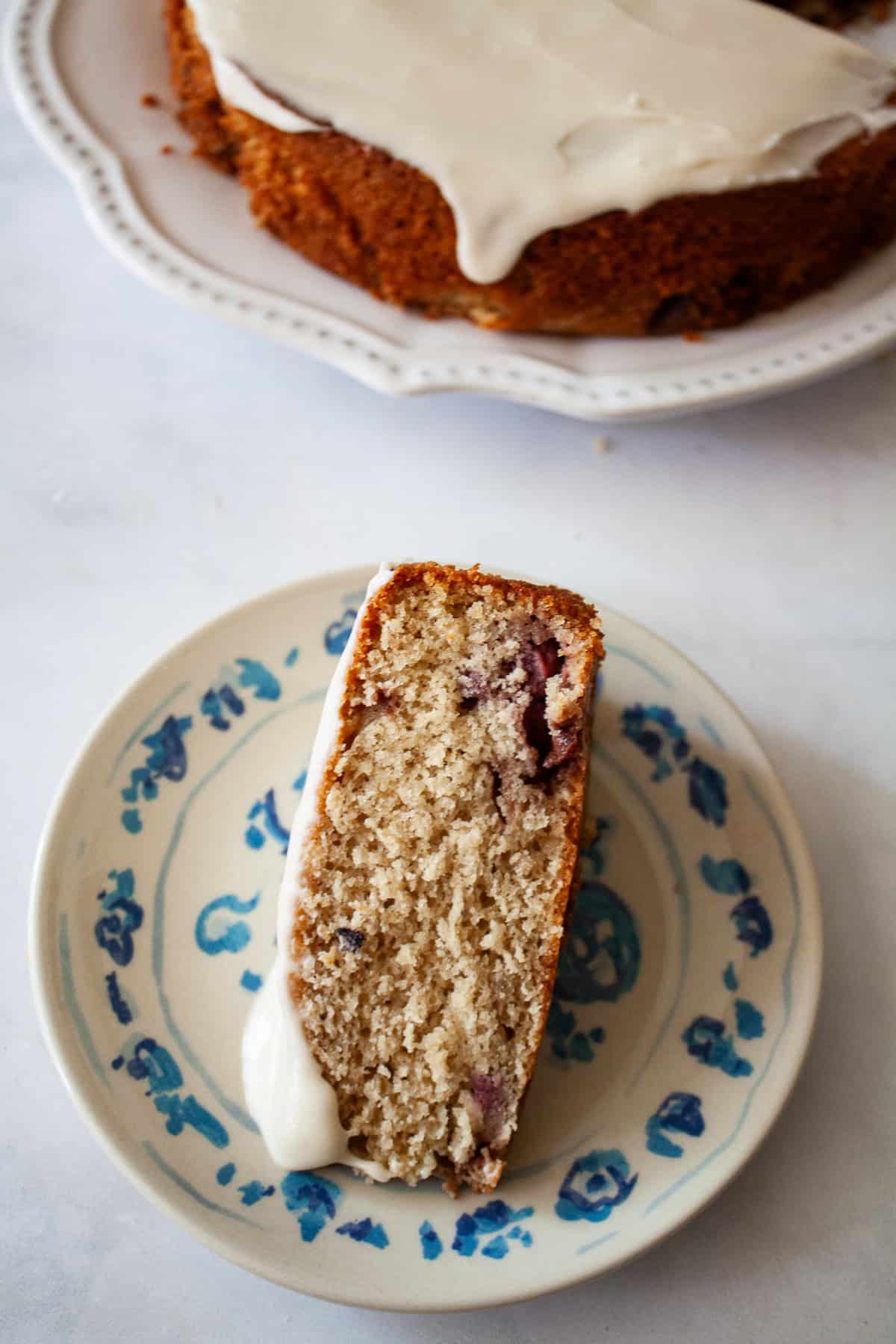 A slice of gluten free berry cake topped with glaze on a plate.