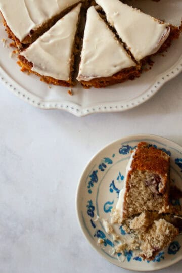 A sliced gluten free berry cake and a piece of cake on a plate.