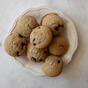 A white plate holds gluten free whole grain berry muffins.