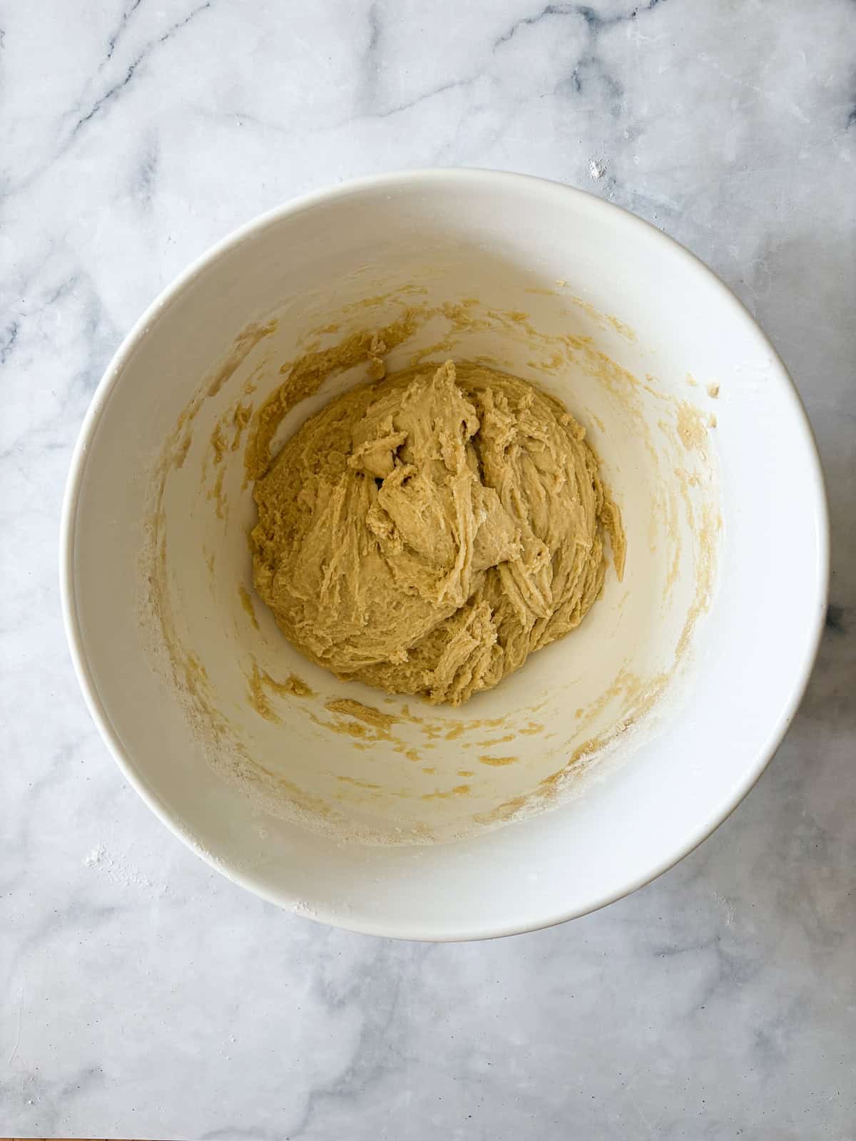A gum-free recipe for a beautifully soft loaf of gluten free challah that's easy enough even for novice gluten-free bread bakers. Gluten free challah dough in a bowl after resting.