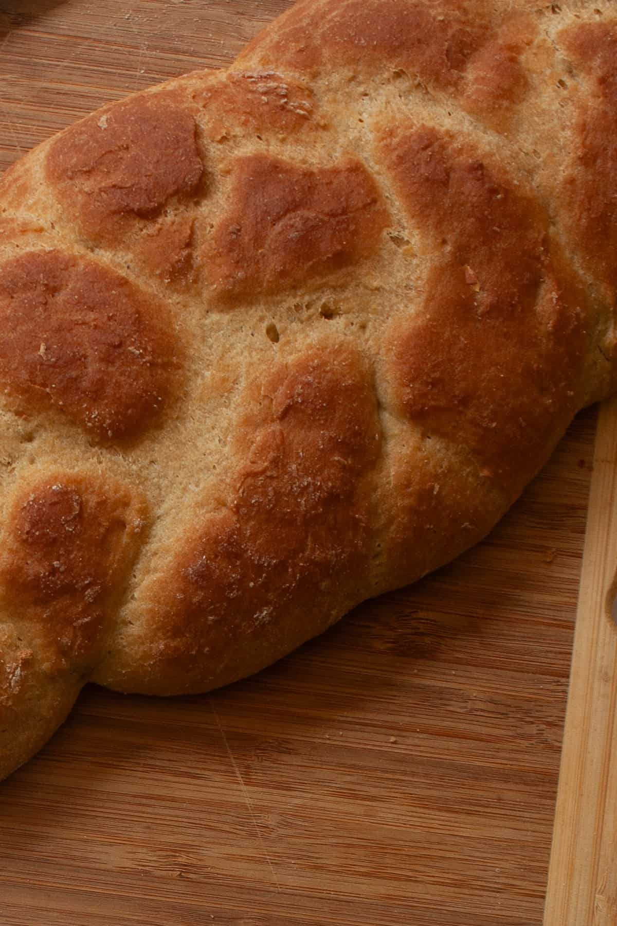 A gum-free recipe for a beautifully soft loaf of gluten free challah that's easy enough even for novice gluten-free bread bakers. A close up of a braided loaf of gluten free challah bread.